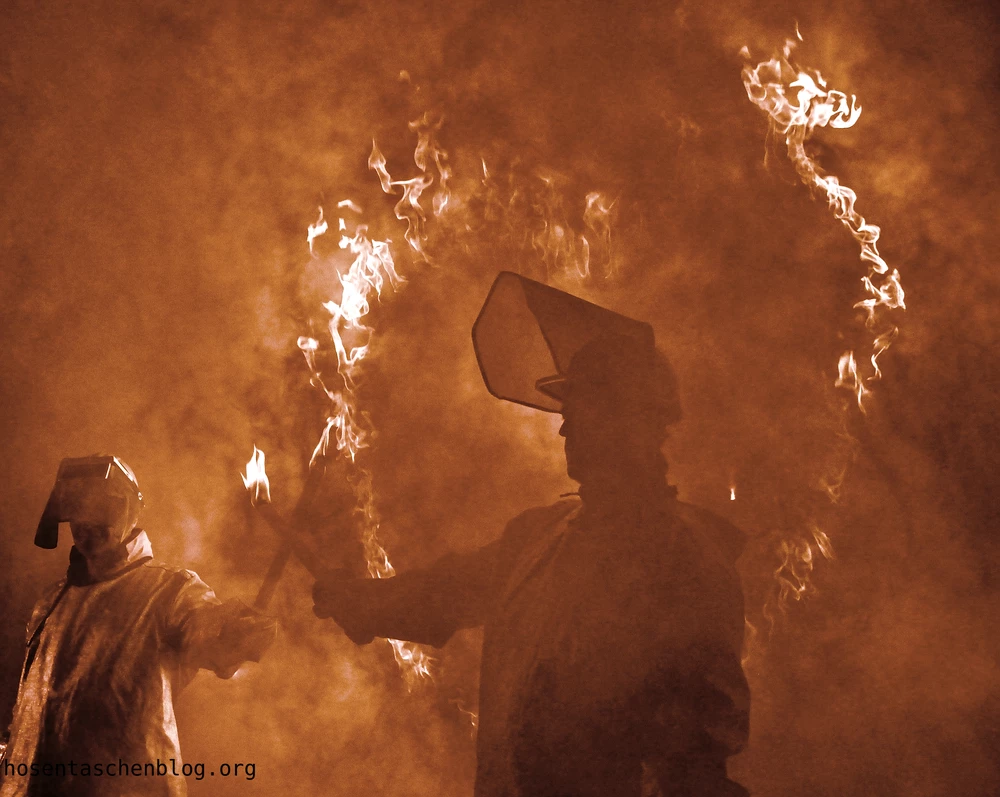 Streikende Stahlarbeiter vor einem brennenden Herz